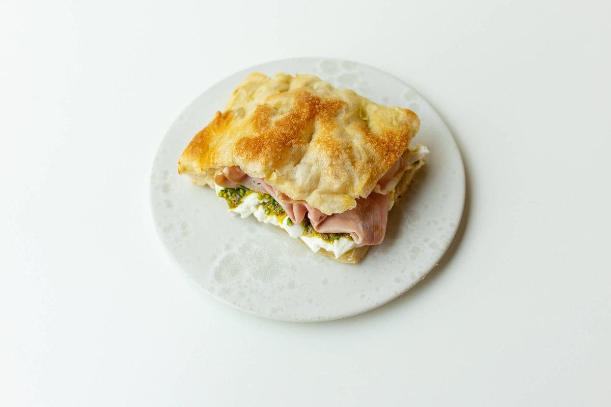 Ein Panino mit Mortadella, Mozzarella und Pistazien
