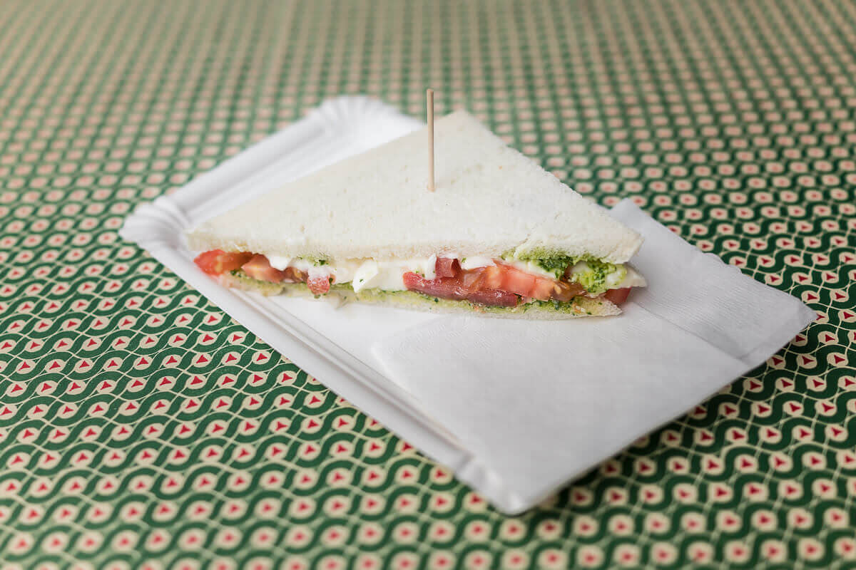 Ein Tramezzino mit Tomate, Mozzarella und Basilikum